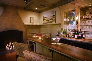 a restaurant with a fireplace and a bar with glasses at Wentworth Mansion in Charleston