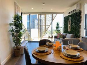 a dining room with a table with chairs and a couch at City Zen Apartment-Gym-BBQ in Adelaide