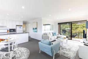ショール・ベイにあるIntrepid 11 Absolute Beachfront Blissのソファとテーブルのあるキッチンとリビングルーム