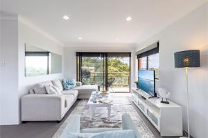 ショール・ベイにあるIntrepid 11 Absolute Beachfront Blissのソファとテレビのある白いリビングルーム