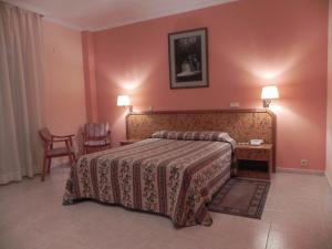 Habitación de hotel con cama, mesa y sillas en Toros de Guisando, en El Tiemblo