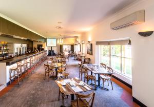 a restaurant with tables and chairs and a bar at Parkes International in Parkes