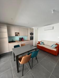 a living room with a table and chairs and a couch at Villa Marie 2 in Le Grau-du-Roi