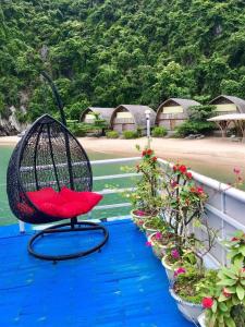 une chaise assise sur un balcon avec des plantes en pot dans l'établissement Bee lucky homestay cat ba Island, à Xuan Dam