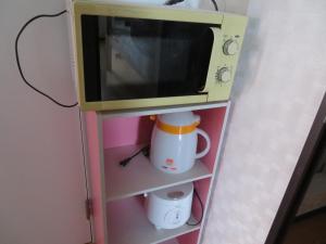a microwave oven sitting on top of a shelf at Sapporo Guest House Nariya in Sapporo