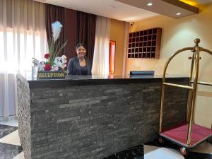 a woman standing at a reception desk in a hotel room at Atmosphere Hotel & Spa in Antananarivo