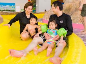 een gezin zittend op een opblaasbaar zwembad in een waterpark bij Jozankei View Hotel in Jozankei