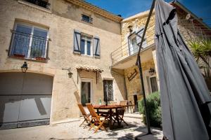 a patio with a table and an umbrella in front of a house at Gîte de Fanny du Moulin de Tartay en Avignon in Avignon