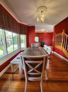 una sala da pranzo con tavolo, sedie e pareti rosse di Lady Heleena's At Strahan a Strahan