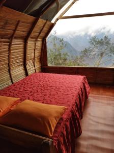 a bed in a room with a large window at Machupicchu EcoLodge in Cusco
