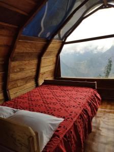 a bed in a room with a large window at Machupicchu EcoLodge in Cusco