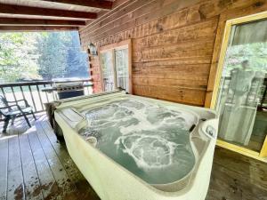 a large bath tub sitting on the deck of a cabin at Whisper Creek in Townsend