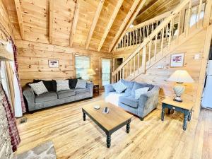 Sala de estar con 2 sofás y mesa en Willow Creek cabin, en Townsend