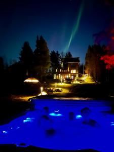a pool at night with a house in the background at Scandi House Levi in Levi