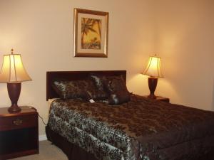 ein Hotelzimmer mit einem Bett und zwei Lampen in der Unterkunft Four Bedroom Villa in Coral Cay in Kissimmee + 30 Fotos
