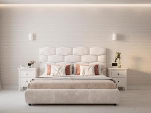 a white bedroom with a large bed with two night stands at Дизайнерська сучасна квартира in Luts'k