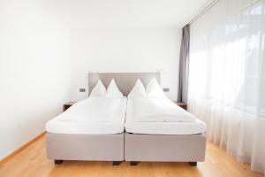 سرير أو أسرّة في غرفة في GUESTHOUSE ZURZACH - Self Check-in