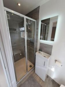 a bathroom with a shower and a toilet and a sink at The Tiny Sea Gem in Jaywick Sands
