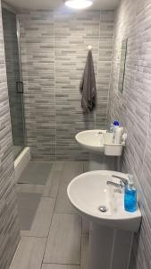 La salle de bains blanche est pourvue d'un lavabo et d'une douche. dans l'établissement Brownlows Inn Guest House formerly The King Harry Accommodation, à Liverpool