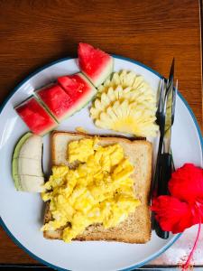 une assiette de nourriture contenant des œufs et des fruits dans l'établissement Rumah Kundun, à Gili Trawangan