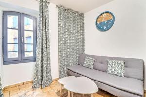 a living room with a couch and a clock on the wall at LA MAISON FAYARD - 3 pers - Centre Clim Wifi Cosy Garage in Saint-Gilles