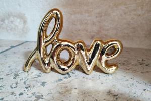 a gold object spelling the word love sitting on a table at LA MAISON FAYARD - 3 pers - Centre Clim Wifi Cosy Garage in Saint-Gilles