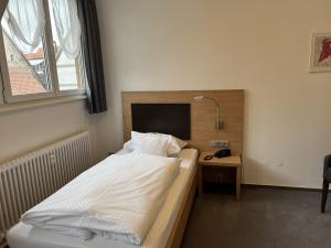 ein Schlafzimmer mit einem Bett und einem Schreibtisch mit einer Lampe in der Unterkunft Hotel Bären in Villingen-Schwenningen