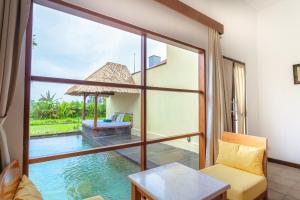 a room with a view of the water and a pool at Alam Puisi Villa Ubud in Ubud