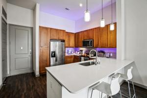 a kitchen with a white counter top and wooden cabinets at Downtown Houston Condo w Pool and Free Parking 6 in Houston