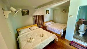 Habitación de hotel con 2 camas y aseo en The Cliff Hostel, M'Pay Bay en Koh Rong Sanloem