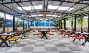 una sala da pranzo con tavoli, sedie e finestre di Treebo Trend Tulip a Pune