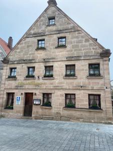 a large stone building with windows on a street at Zirndorf Gästehaus in Zirndorf