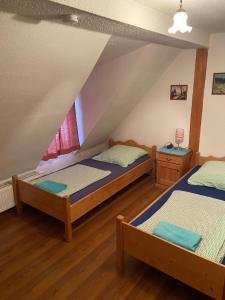 2 Betten in einem Zimmer mit Dachgeschoss in der Unterkunft Zirndorf Gästehaus in Zirndorf