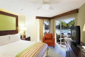 - une chambre avec un lit, une télévision et une chaise dans l'établissement Fiesta Resort All Inclusive Central Pacific - Costa Rica, à El Roble