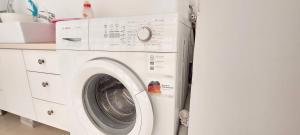 uma máquina de lavar e secar roupa branca numa cozinha em Sitrin apartment Leonardo Hotel Area Ashdod em Ashdod