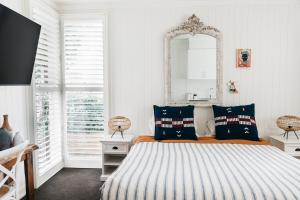 a bedroom with a bed with a mirror on the wall at Anchor Geelong in Geelong