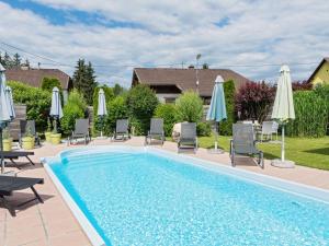 una piscina con sillas y sombrillas en Adults only apartment with pool, en Wasserhofen
