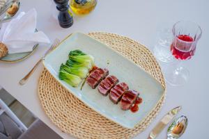 a plate with sushi and vegetables on a table at Malahini Kuda Bandos Resort in North Male Atoll