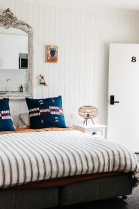 a bedroom with a bed with blue pillows and a mirror at Anchor Geelong in Geelong