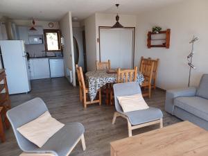 豐羅默奧代洛維亞的住宿－Les Sorbiers - Grand T4 ensoleillé avec Vue Panoramique，厨房以及带桌椅的起居室。
