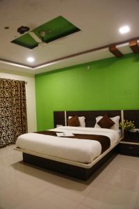 Un dormitorio con una pared verde y una cama en Shriyan Farmhouse Mahabaleshwar, en Mahabaleshwar