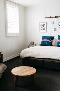 a bedroom with a bed and a wooden stool at Anchor Geelong in Geelong