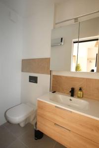 a bathroom with a toilet and a sink and a mirror at Appart neuf, parfaitement situé 6min CV-8min GARE in Arles
