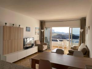 a living room with a couch and a television and a table at El Ancla in Callao Salvaje