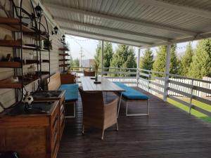 a patio with a table and chairs on a deck at HYGGE HOME уютный коттедж с террасой и баней для проживания нескольких семей in Besqaynar