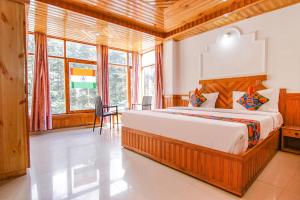 a bedroom with a large bed in a room with windows at FabHotel Hira Invitation in Manāli