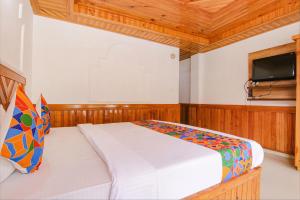 a bedroom with a bed and a flat screen tv at FabHotel Hira Invitation in Manāli