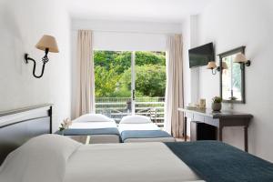 um quarto com 2 camas e uma janela em Louis Ionian Sun em Agios Ioannis Peristerion