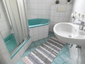 La salle de bains est pourvue d'un lavabo et d'une baignoire. dans l'établissement SUNNYHOME Monteurwohnungen und Apartments in Weiden, à Moosbürg