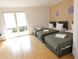 a bedroom with two beds and a large window at SUNNYHOME Monteurwohnungen und Apartments in Weiden in Moosbürg